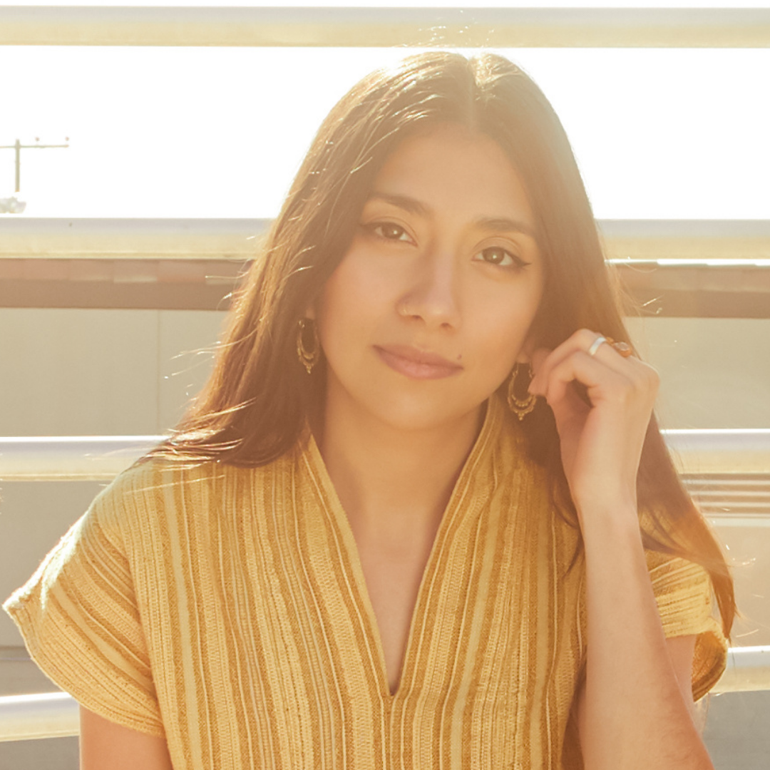 A cute girl smiling with long brown hair in a light pink background
