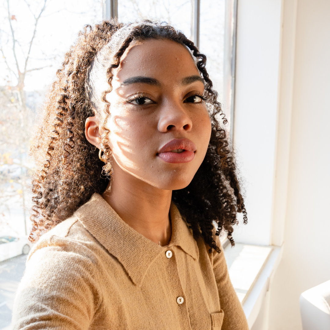 A black man with pink t-shirt in a light pink background