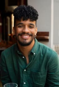 Black man smiling in front of a phone camera